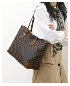 Brown monogram tote bag styled on shoulder with white shirt for a classic look