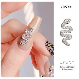 Detail of silver snake nail art charm with white rhinestones measuring 1.7x0.7cm