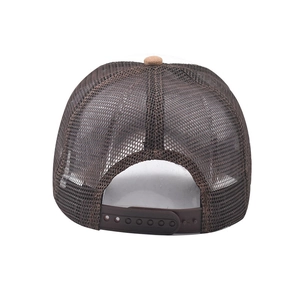Detail view of the brown mesh trucker hat with an adjustable snapback closure on white background