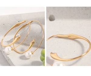 Macro detail of S925 silver hallmark and pearl attachment on the gold hoop earring