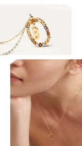 Detail view of gold letter B necklace with colorful crystals and model on-neck shot