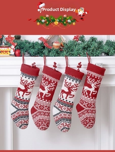 Detail of four knit Christmas stockings with reindeer patterns hanging on a fireplace