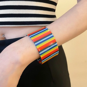 Macro shot of colorful striped acrylic cuff bracelet showing polished finish and textures