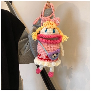 Detail of handmade crochet crossbody bag with cute big mouth design and pink ribbon