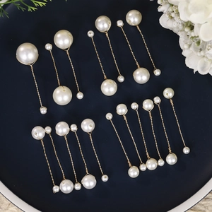 Elegant collection of handmade bridal pearl hair clips and earrings set on blue plate