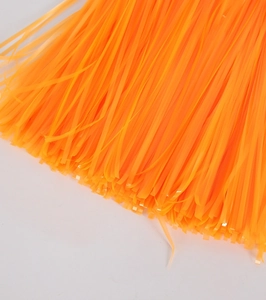 Close-up texture of orange neon tinsel foil fringe for party backdrop decoration