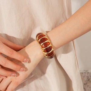 Macro view of vintage amber resin segments in gold metal frame on a women's bracelet