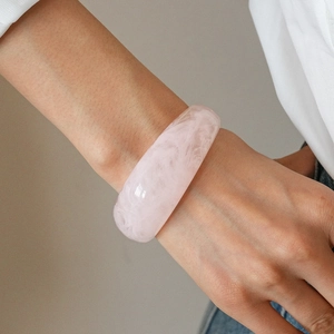 Close-up of pink resin marble bangle showing the detailed texture on a woman's wrist