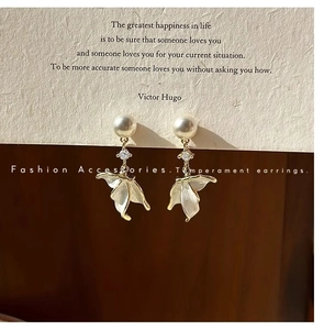 Detailed view of pearl petal earrings featuring gold trim and sparkling rhinestone accents