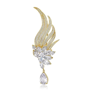 French vintage phoenix wing brooch with golden tassels and natural pearls on white backdrop