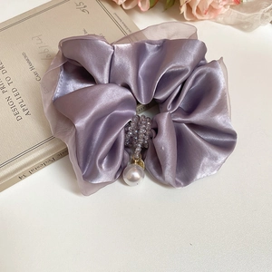 Close-up of purple satin scrunchie featuring elegant crystal beads and a large pearl charm