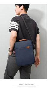 Men's navy oxford laptop bag with leather handles shown in a side-view lifestyle shot