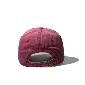 Detail view of burgundy washed cotton baseball cap with adjustable bronze metal buckle