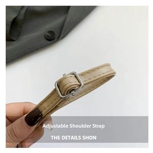 Close-up of adjustable beige synthetic leather shoulder strap with silver metal buckle