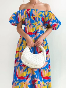 Detail of blue off-shoulder dress featuring vibrant yellow and red floral prints