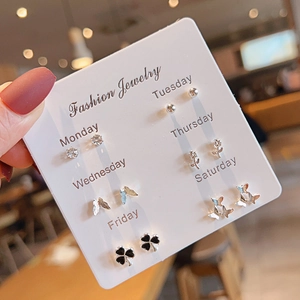 Detailed view of a 6-pair silver earring set with floral and butterfly studs on cards
