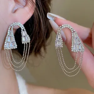 Boucles d'oreilles géométriques argentées avec zircons et pompons au style moderne