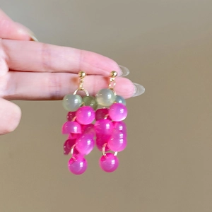 Détail des boucles d'oreilles en forme de grappe avec perles roses et vertes