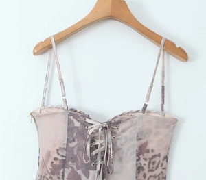 Detail of printed corset top with front lace-up design and metal eyelets on hanger