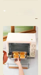 Square stainless steel plate baking four croissants inside a modern white oven