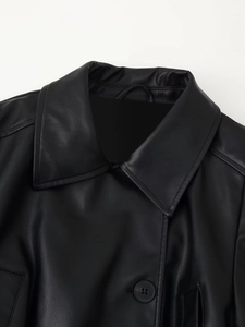 Détail du col et du bouton d'une veste en similicuir noir avec couture de haute précision