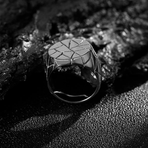 Macro detail of men's stainless steel signet ring with geometric cracked texture