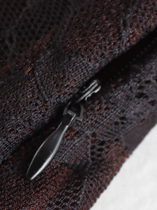 Macro shot of black lace fabric texture and functional invisible zipper closure detail