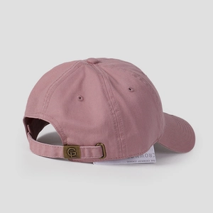 Detail view of pink baseball cap with adjustable copper buckle and engraved logo clasp