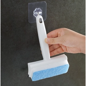 White hand-held window glass wiper with blue sponge layer and clear wall hook on gray wall