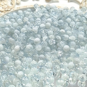 Macro shot of 10mm light blue and white cracked glass beads with ice texture for DIY jewelry