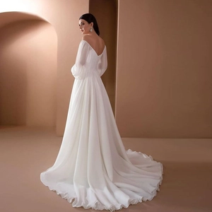 Elegant white off-shoulder wedding gown with long lantern sleeves and a flowing long train