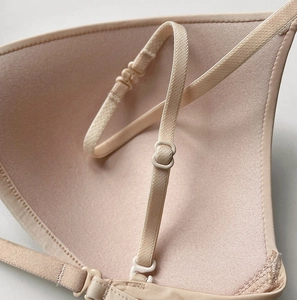 Detail of adjustable straps and seamless fabric texture on a beige triangle bra cup