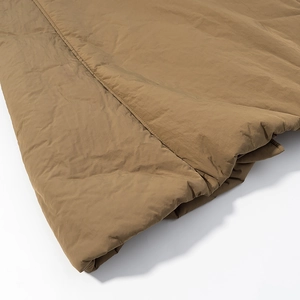 Close-up of khaki padded coat fabric showing smooth texture and detailed stitching