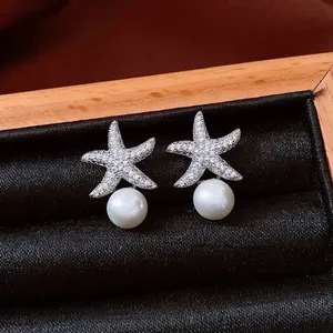 Elegant starfish earrings with cubic zirconia and white pearls on black silk display box