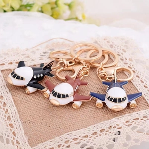 Detailed view of airplane keychains in black, brown and navy blue with rhinestones