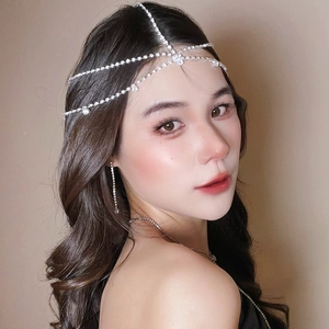 Détail d'un bijou de tête argenté à strass avec boucles d'oreilles à franges brillantes