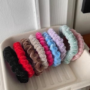 Macro view of velvet scrunchies in nine vibrant colors with ribbed texture detailing