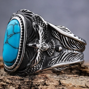 Macro detail of vintage eagle ring featuring inlaid turquoise and feather carvings