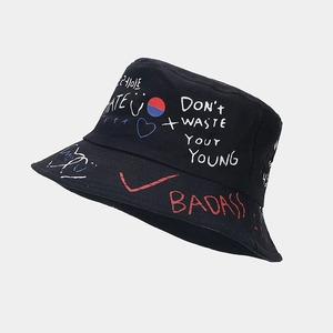 Détail du chapeau bob noir style graffiti avec lettres blanches et icônes cœur rouges
