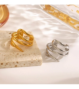 Detail of gold and silver spiral rings on travertine stone with soft shadow lighting