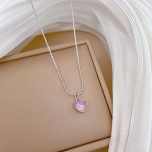 Detail of silver chain with pink heart pendant featuring delicate beaded edging decoration