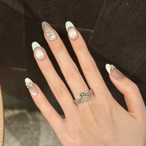 Detailed view of silver orb ring with pavé crystals and elegant cat-eye french nails
