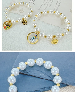 Detail of beaded pearl bracelets featuring colorful heart charms and evil eye pendants