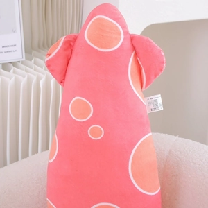 Detailed macro shot of soft pink plush squid toy with orange polka dots on a white sofa