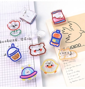Detailed view of colorful cartoon acrylic clips scattered on a notebook and card