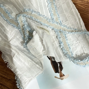Gros plan sur la texture de dentelle avec bordure bleu clair et fils métalliques dorés