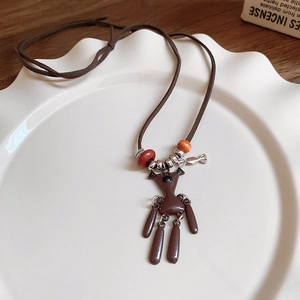 Close-up of vintage brown bear pendant with colorful beads on a leather rope sweater chain