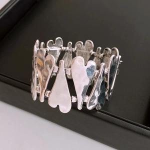 Detail of silver heart stretch bracelet featuring textured hammered metal surface