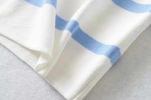 Close-up of blue and white striped fine knit fabric with smooth hem stitching detail