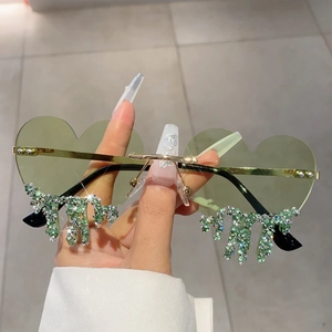 Detail of heart-shaped rimless sunglasses with green crystal water-drop tassels and gold arms